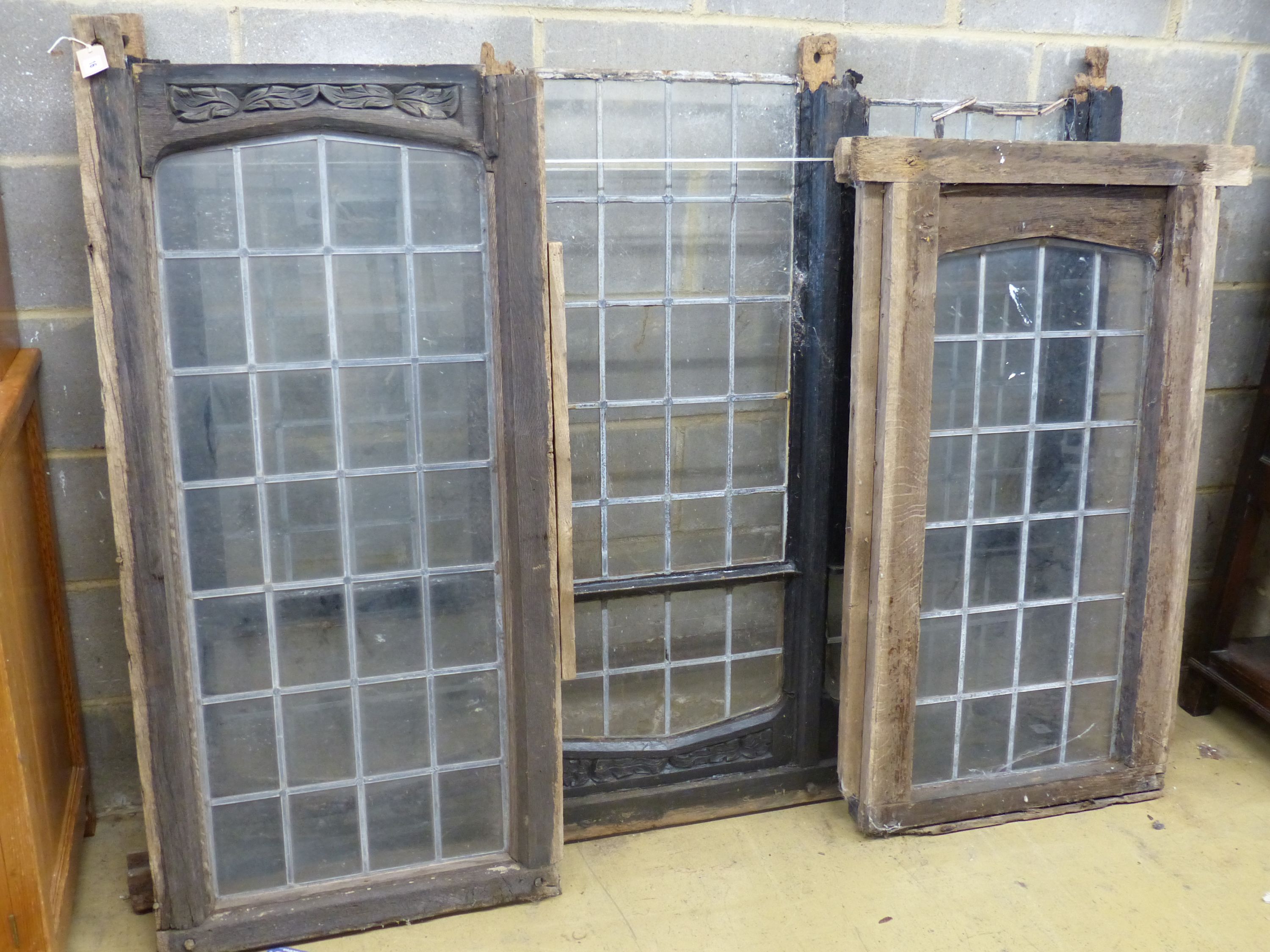 Three old carved oak window frames with leaded lights, largest width 170cm, height 134cm
